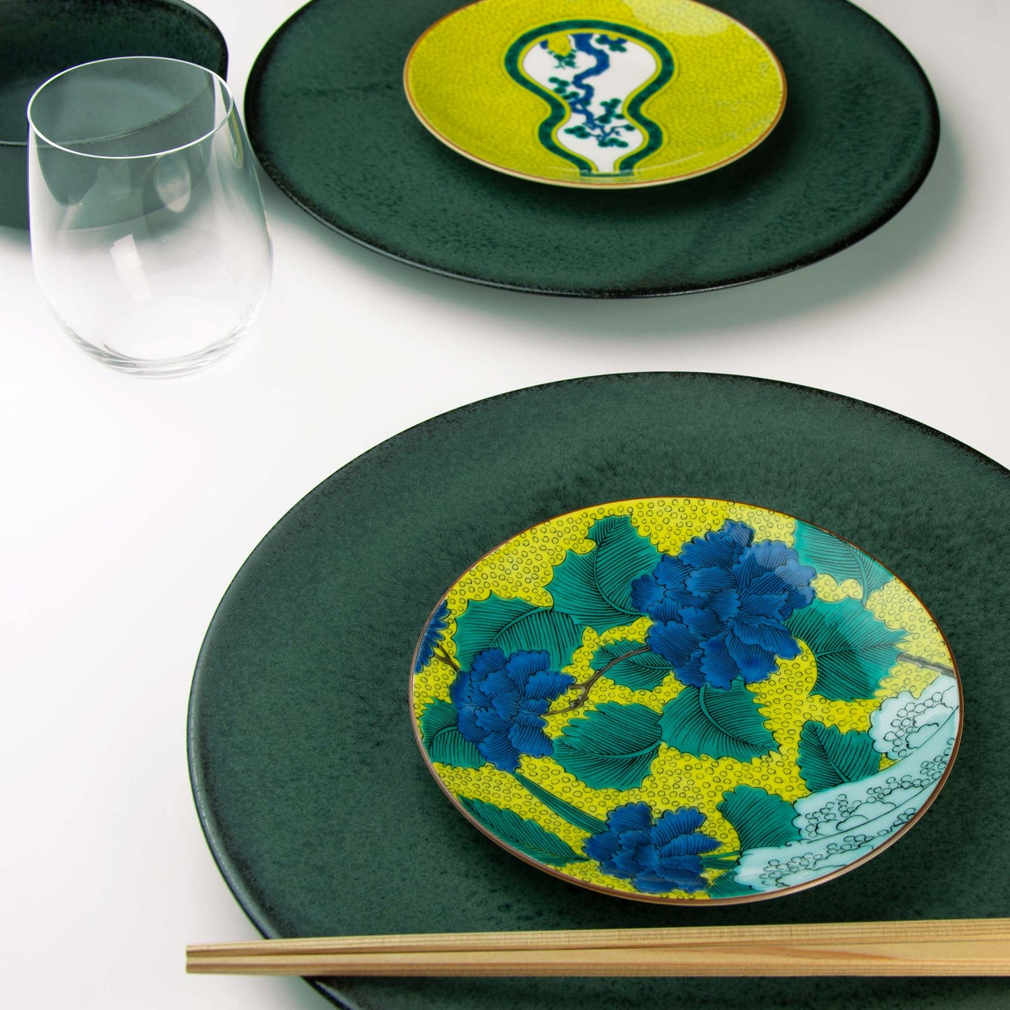 Rich blue peonies and green leaves set on a background of yellow and blue waves. Paired with Koku dinnerware.