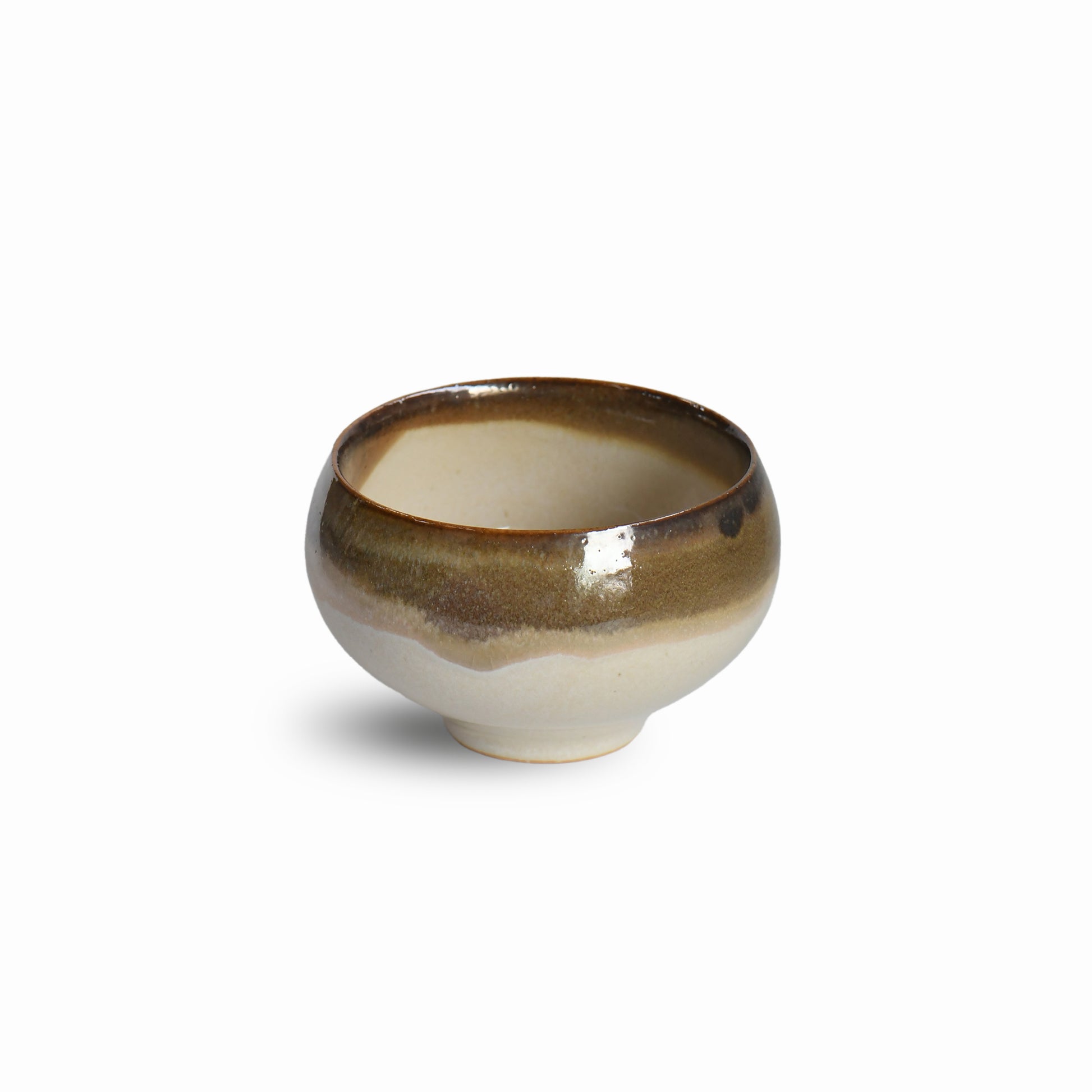 Yuhaku matcha bowl by Kozan Kiln with flowing amber-brown glaze over ivory base, front view