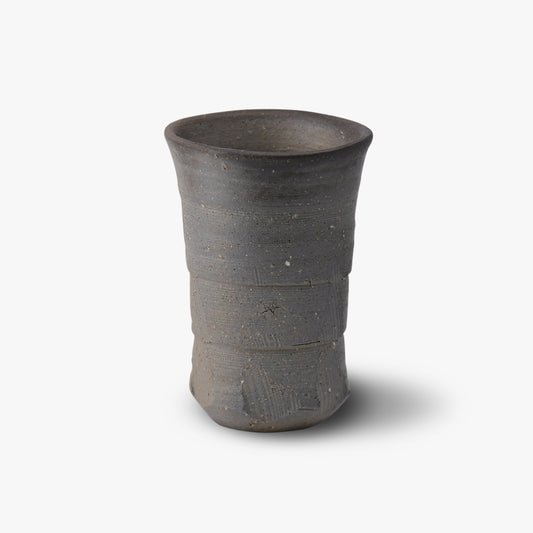 A dark gray ceramic tumbler with a textured surface, likely handcrafted.