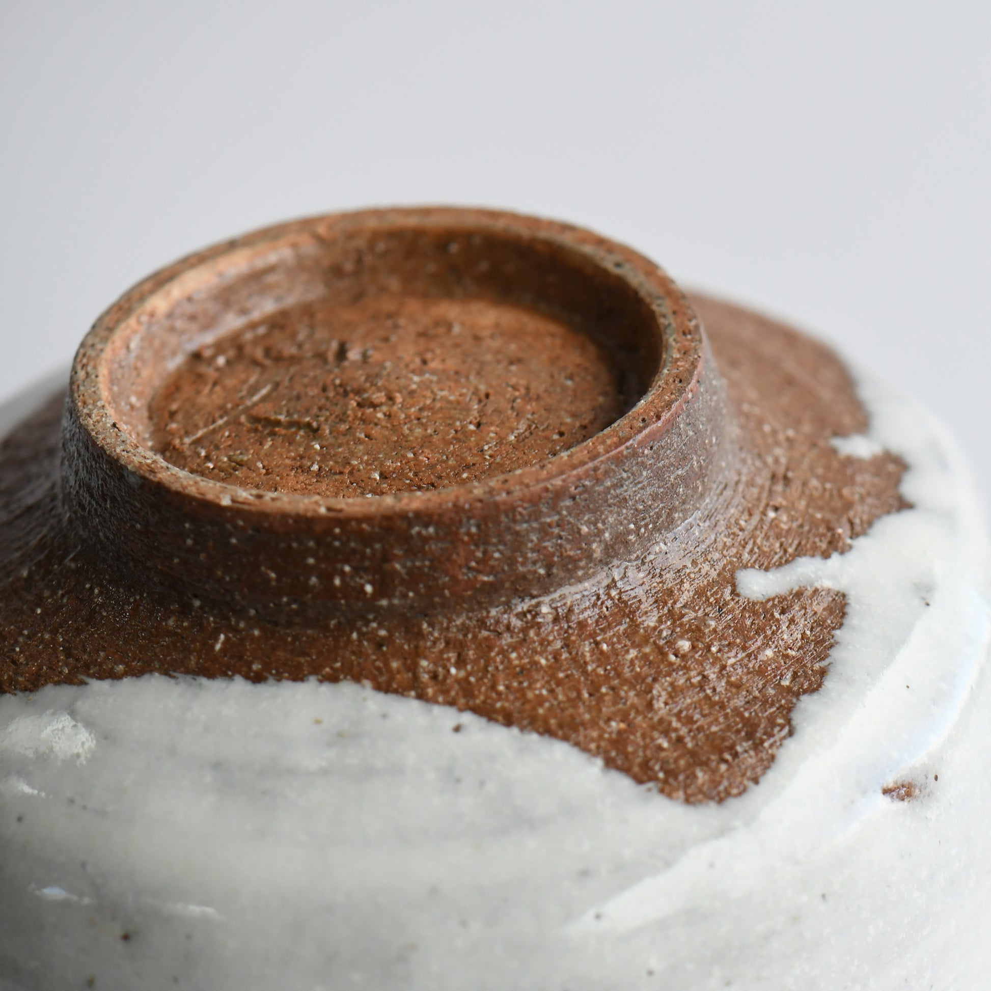Bottom detail of matcha bowl revealing reddish clay foot and hand-thrown base