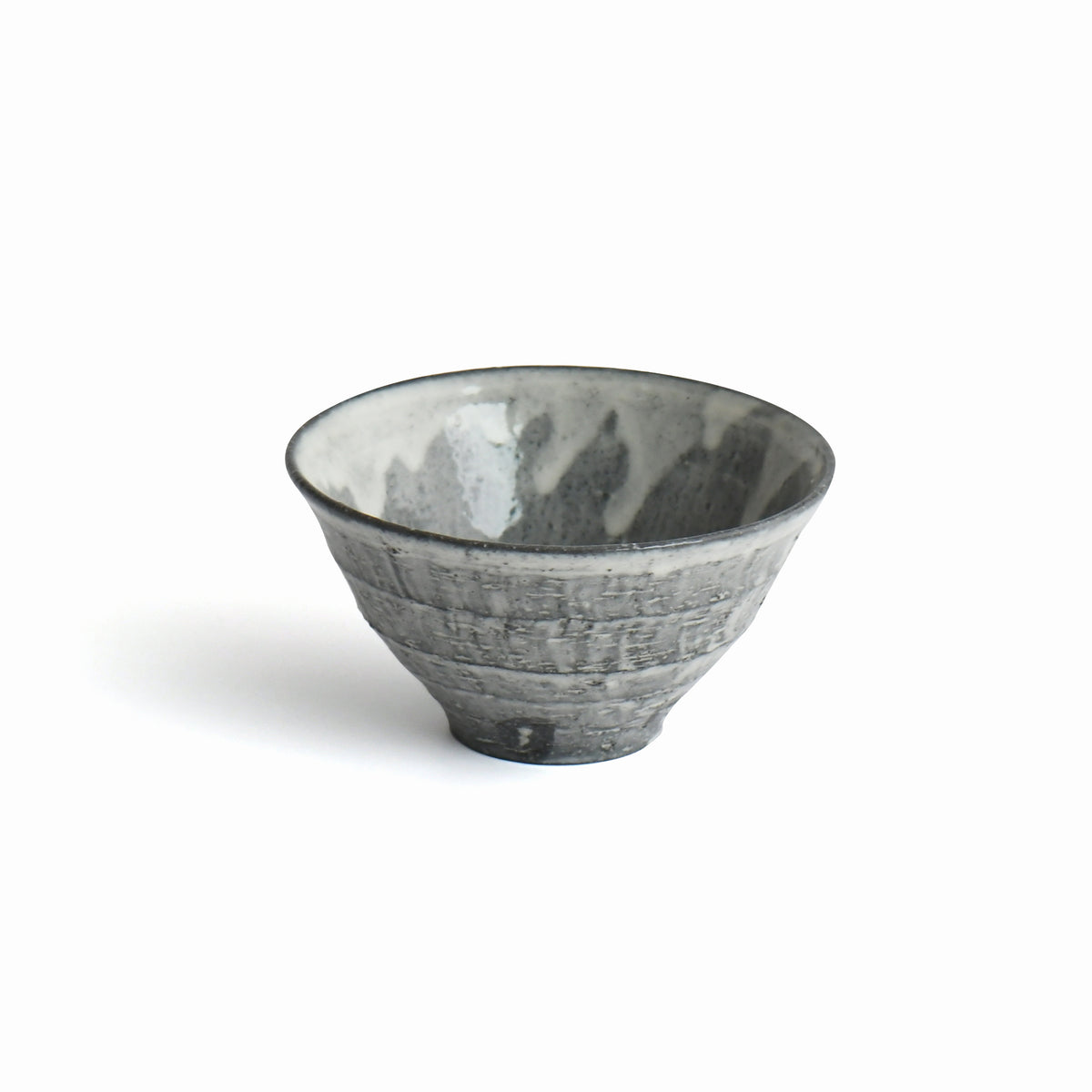 Sumine Rice Bowl by Takeshi Honda with flowing white glaze over a charcoal-gray textured surface.