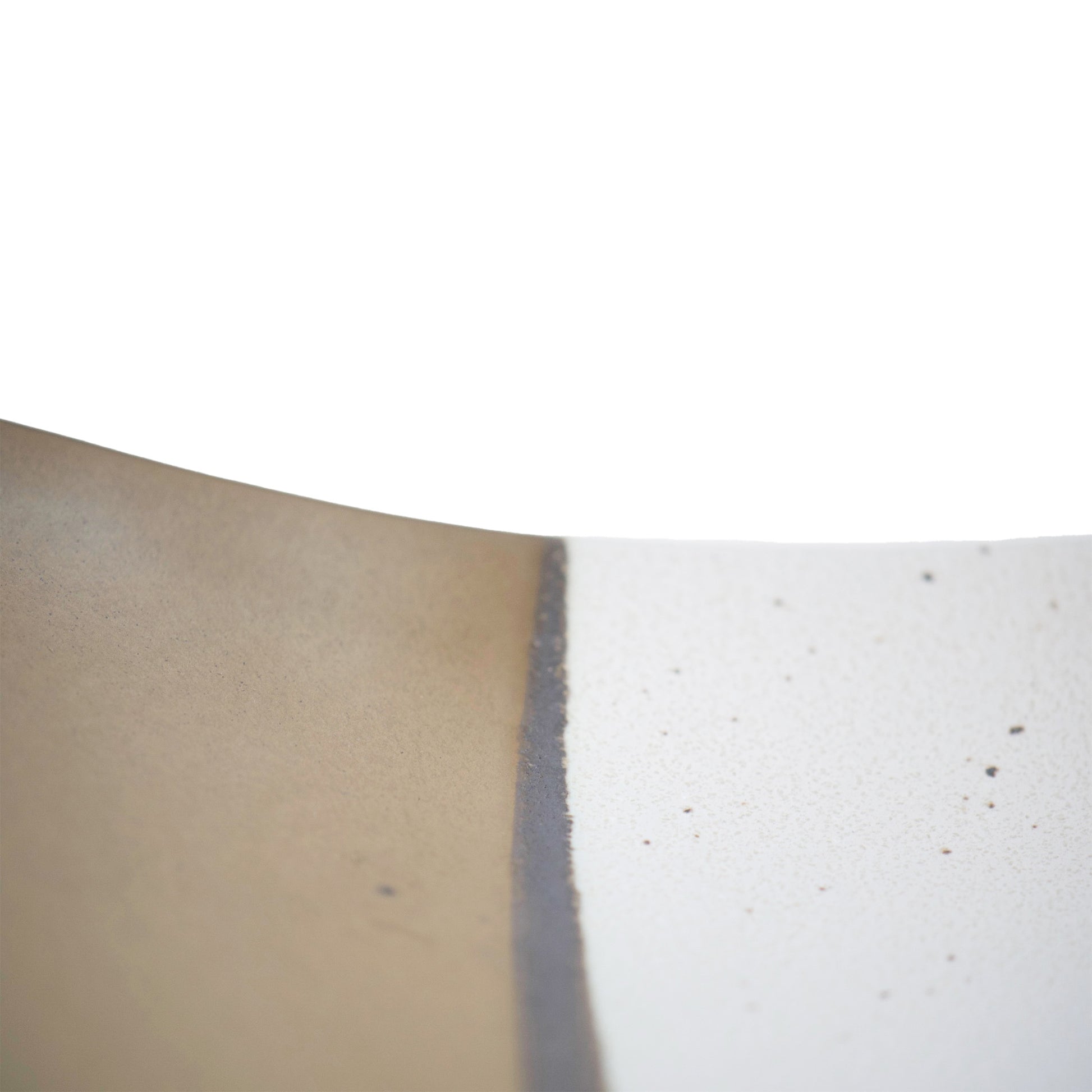 Close look of the edge of the table.  The white part has small black speckles and there is dark brown line in between with the gold.