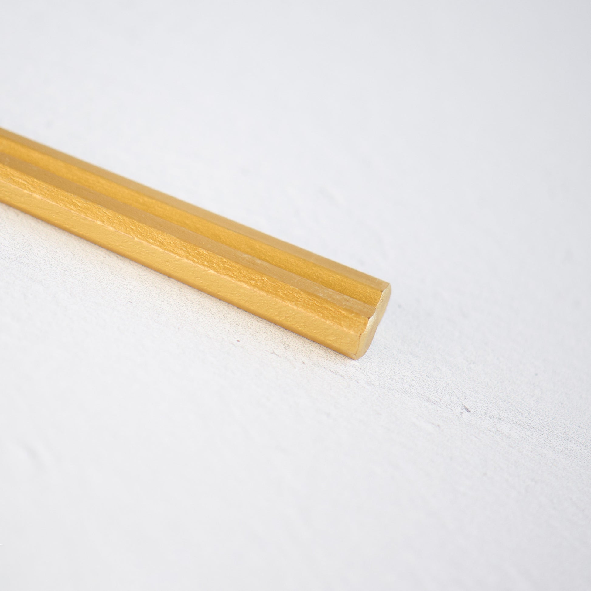 A close-up view of the elaborate gold-plated with lacquerheads of a pair of chopsticks, exquisitely crafted for a touch of luxury. Modern and sleek design.