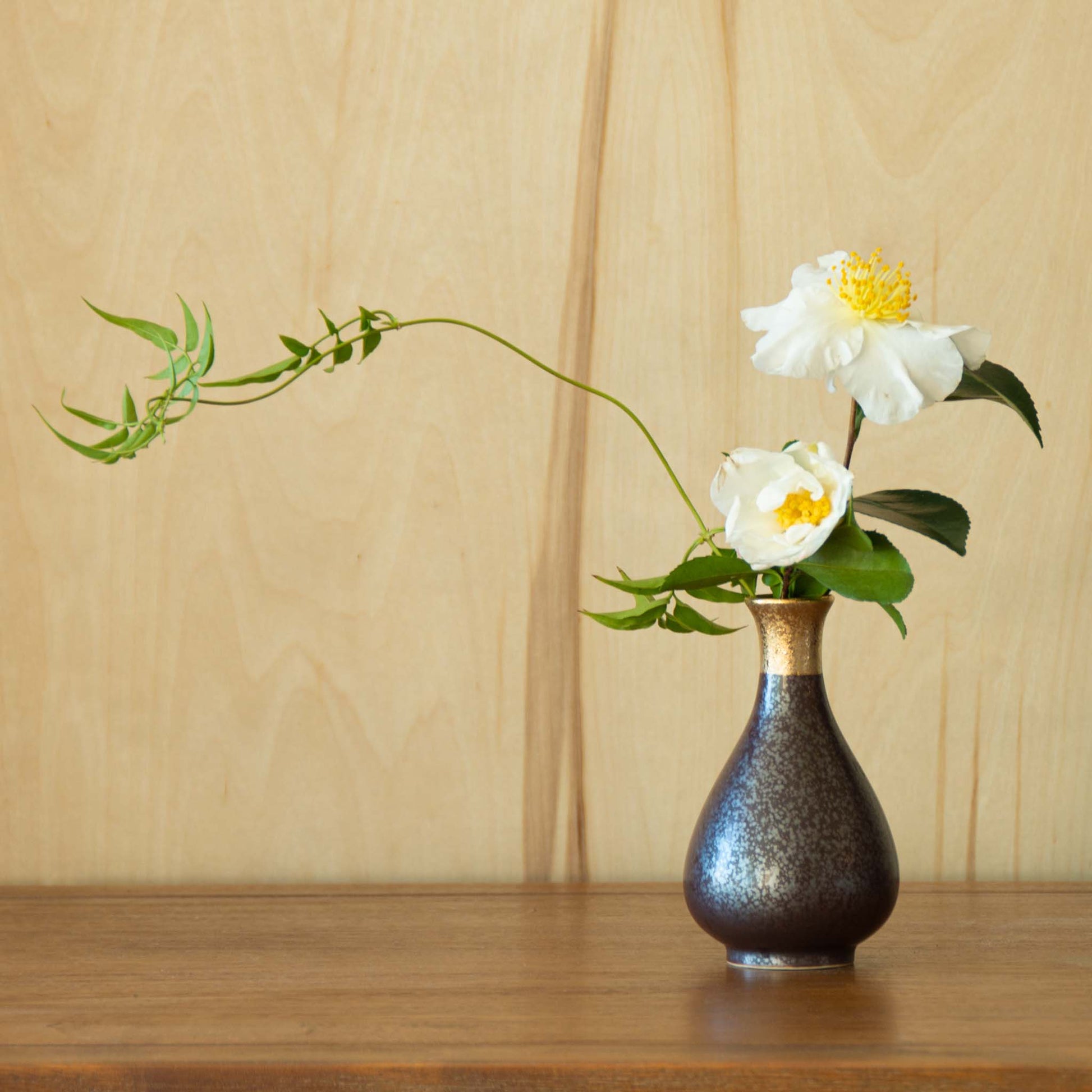 sake container vase with green foliage combined with white camelia